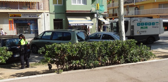 Una agente multa un turismo, mientras un vehículo de Nora limpia con dificultad la calzada, ayer en la Avenida Catalunya / Foto: JFG