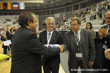 Josep Trias, i Celestino Lillo, en el moment de rebre el relleu per part d'un membre de la Federació de Patinatge