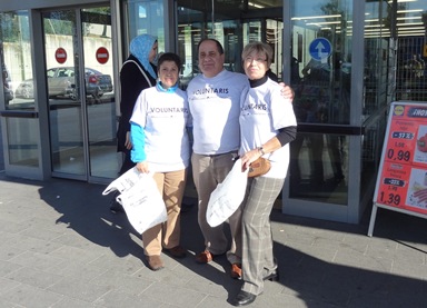 Los voluntarios entregaban bolsas a las personas que han colaborado, para facilitar el gesto solidario