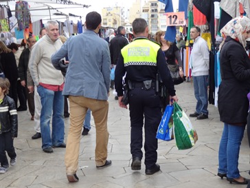 UN agente camina por el mercadillo tras requisar material que se vendía de forma ilícita
