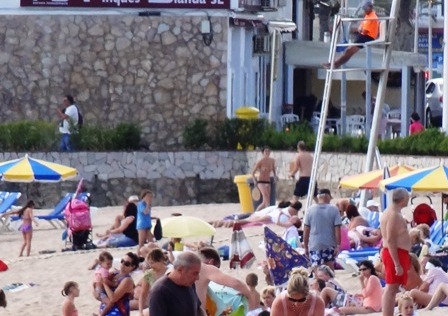 A la part superior dreta de la imatge un socorrista observa els usuaris de la platja